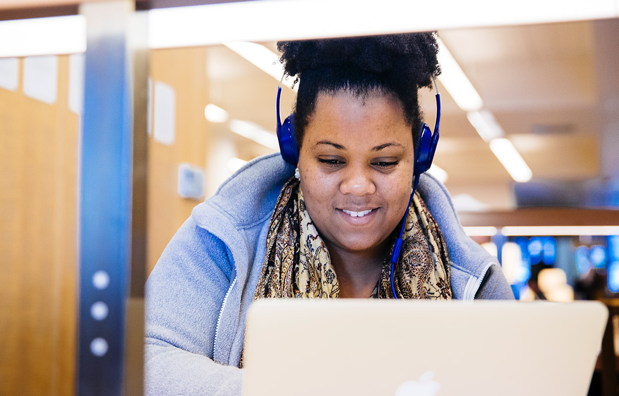 Student on laptop smiling