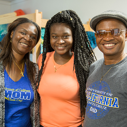 Student smiling with mom and dad